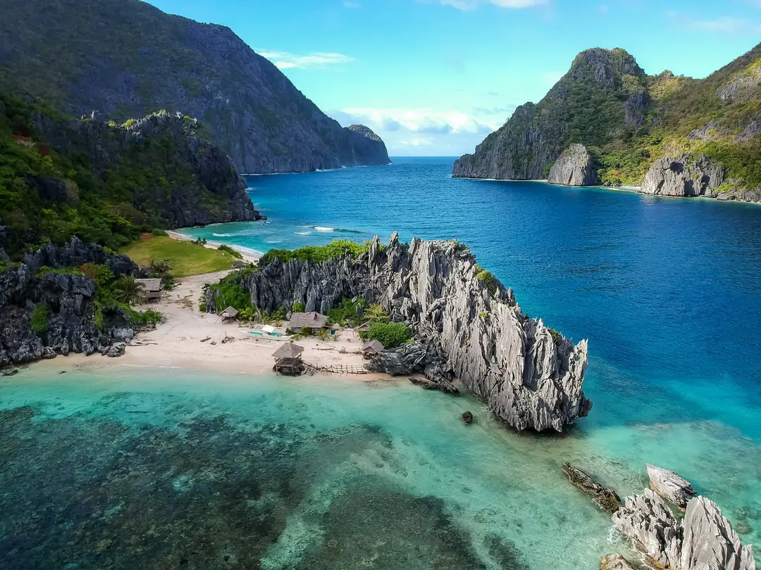 Limestone cliffs, a small beach and turquoise water near El Nido in Palawan, the Philippines